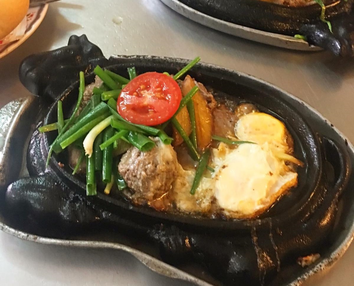 Bò bít tết - beef steak is commonly served on cow-shaped cast iron pans